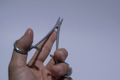 Close-up of hand holding eyeglasses against white background