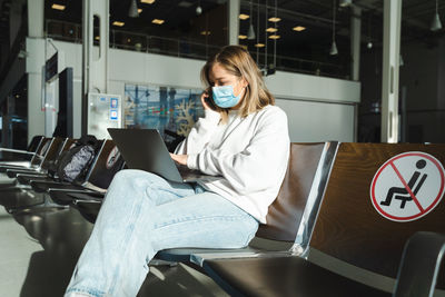 Young woman using mobile phone while sitting in gym