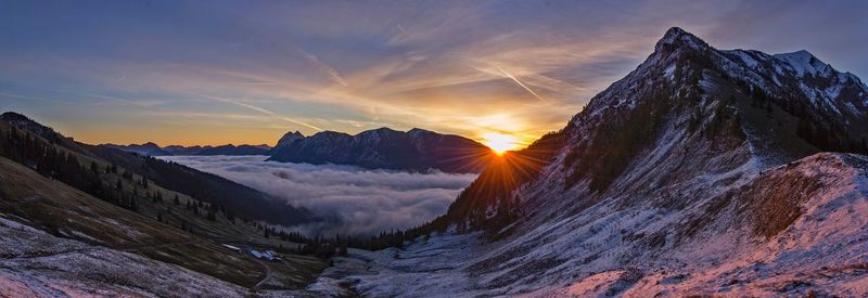 Scenic view of snowcapped mountains against sky during sunset