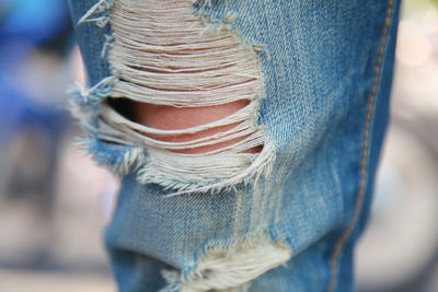 Close-up of person wearing torn jeans pant