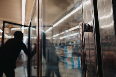 Rear view of man standing by train window