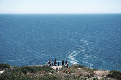 High angle view of people on beach against clear sky