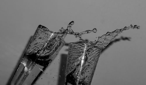 Close-up of water drops on glass against white background