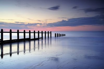 Pier on sea at sunset