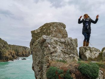 Low angle view of woman standing on rock