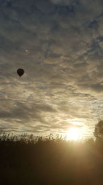 Silhouette hot air balloon against sky during sunset