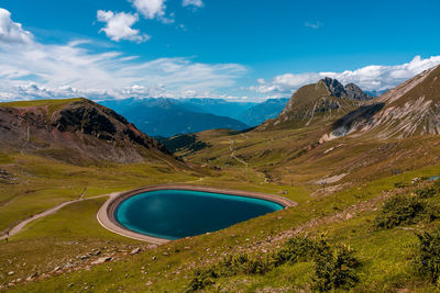 Scenic view of lake by mountains against sky