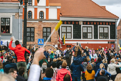 People on street against buildings in city