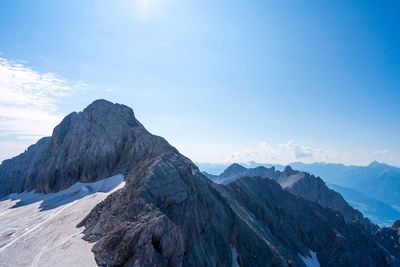 Scenic view of mountains against blue sky