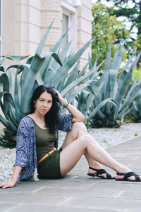 Young woman sitting on footpath