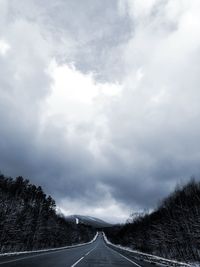 View of country road against cloudy sky