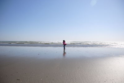 Full length of man standing on beach against sky