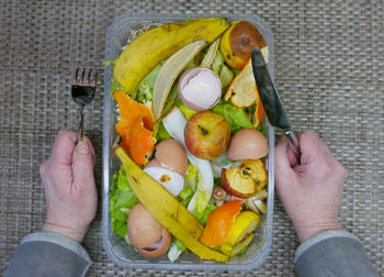 Cropped hand of person with food peel at table