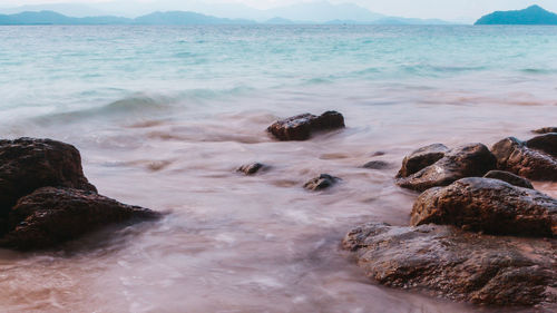 Scenic view of rocks in sea against sky