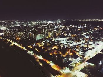 High angle view of illuminated cityscape against sky at night