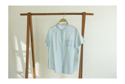 Clothes hanging on rack against white background