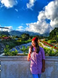 Full length of woman standing on mountain against sky