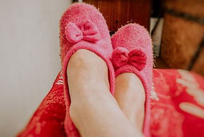 Low section of woman wearing slippers at home