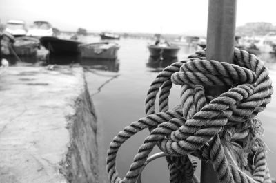 Close-up of rope tied on wooden post in sea