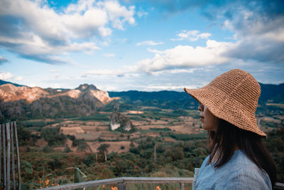 Rear view of woman looking at mountains against sky