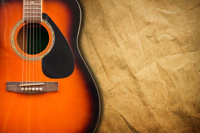 High angle view of guitar on brown paper