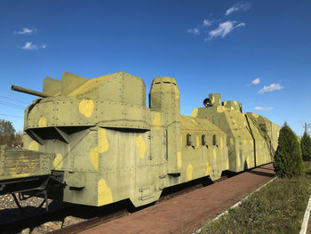 Close-up of yellow train on field against sky