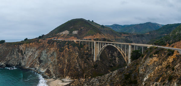 Bridge over mountains against sky