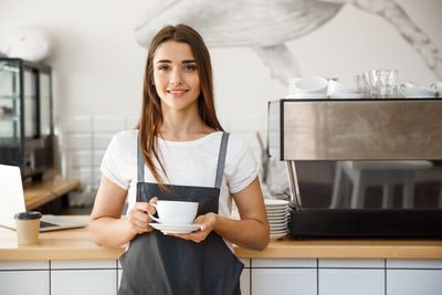 Portrait of smiling young woman with coffee