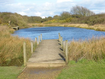 Wooden jetty leading to calm lake