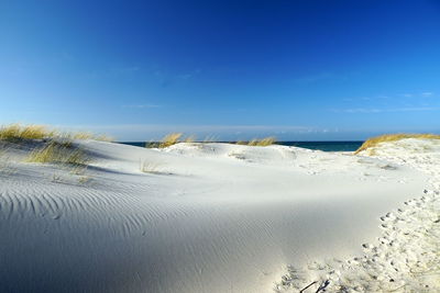 Scenic view of beach against blue sky