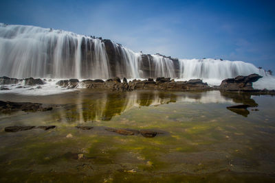 Scenic view of waterfall against sky