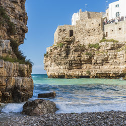 Rocks on beach against clear sky