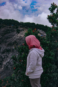 Side view of woman wearing hijab while standing by plants
