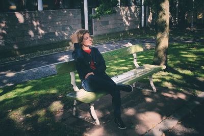 Woman sitting on bench in park