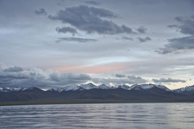 Scenic view of lake and snowcapped mountains against sky