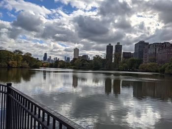 Scenic view of river by buildings against sky