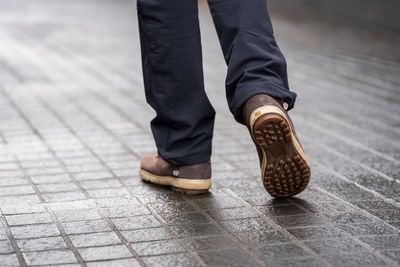 Low section of man standing on footpath