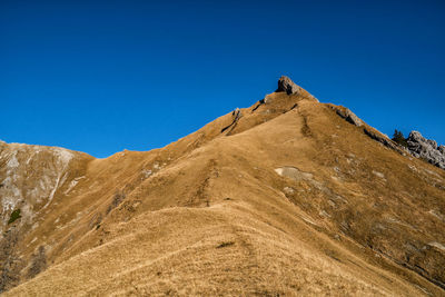 Low angle view of a mountain against clear blue sky