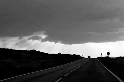 Panoramic view of road amidst field against sky