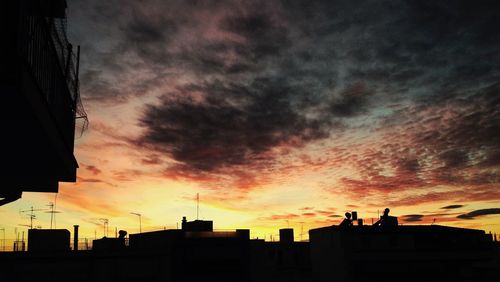 Silhouette of building against cloudy sky