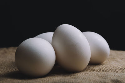 Close-up of eggs on table against black background