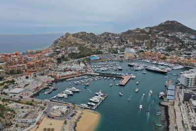 High angle view of city by sea against sky