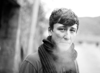 Close-up portrait of young man exhaling breath vapor