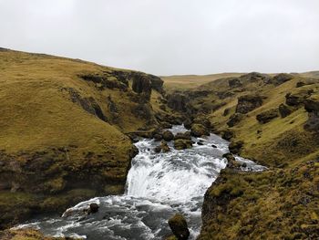 Scenic view of waterfall against sky