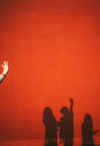 Shadow of people on red wall