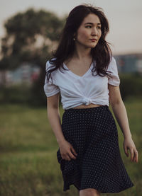 Beautiful young woman standing on field