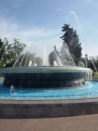 Fountain in garden against sky on sunny day