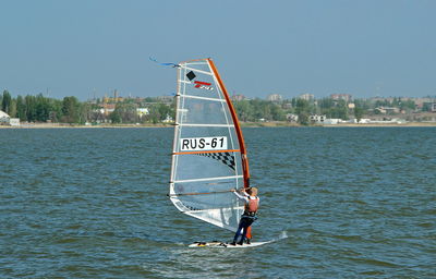 Man with umbrella on sea against sky