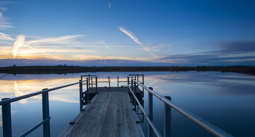 Jetty in lake against sky