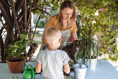 Family planting flowers together. spring houseplant care, repotting houseplants. happy family mom